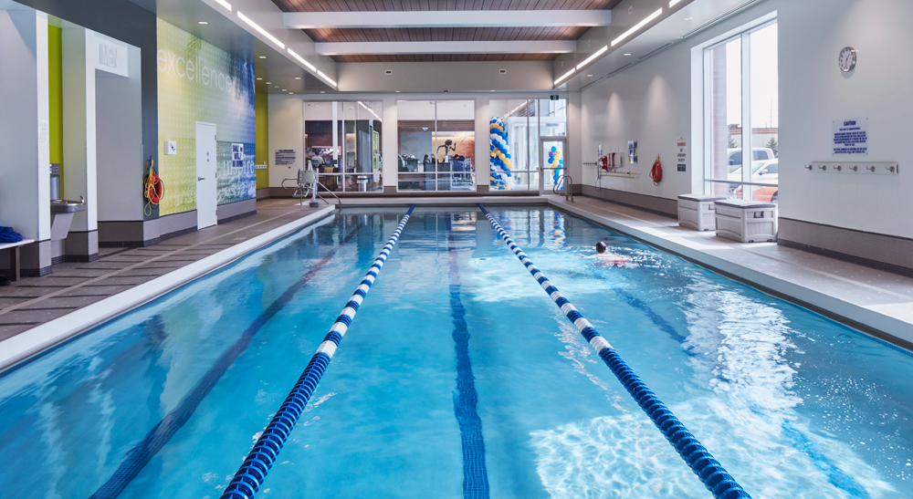 Person swimming laps in the indoor lap pool at LA Fitness in Mississauga, Ontario